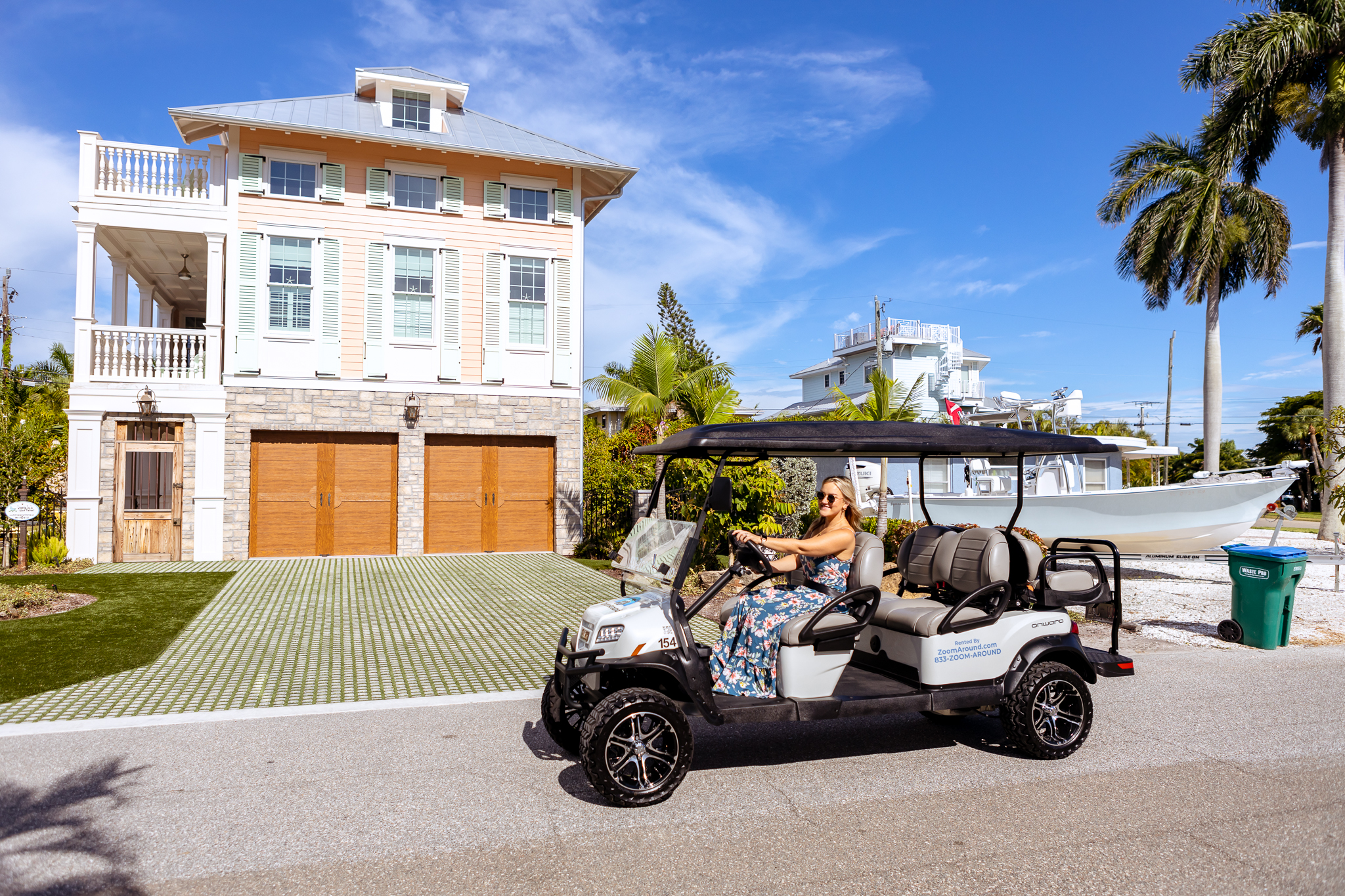 A ZoomAround customer driving a golf cart through a residential neighborhood.